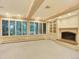 Spacious room with a fireplace, built-in shelving, and window shutters at 12135 W Applewood Knolls Dr, Lakewood, CO 80215