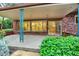 A cozy covered patio with brick accents and mature landscaping, perfect for relaxing at 12135 W Applewood Knolls Dr, Lakewood, CO 80215