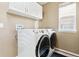 Bright laundry room with washer, dryer, and overhead cabinets at 5630 Spruce Ave, Castle Rock, CO 80104