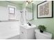 Clean bathroom with white tile, a shower-tub combination, and stylish mirror and art at 1755 Quince St, Denver, CO 80220