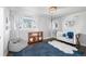 Sunlit bedroom with crib, bean bag chair, and book shelves under a large window at 5510 E 2Nd Ave, Denver, CO 80220