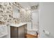 Stylish bathroom featuring designer wallpaper, gold fixtures, and a walk-in shower with new tile at 4012 S Newport Way, Denver, CO 80237