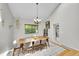 Bright dining room featuring vaulted ceiling, modern chandelier, light gray walls and large windows overlooking greenery at 4012 S Newport Way, Denver, CO 80237