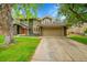 A classic exterior featuring stone accents, an attached garage, and a balcony above the garage at 4012 S Newport Way, Denver, CO 80237