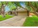 Charming exterior view of the home, featuring an attached two car garage and mature trees at 4012 S Newport Way, Denver, CO 80237