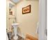 This powder room features a pedestal sink, neutral paint, and decorative artwork adding charm and functionality to the space at 4012 S Newport Way, Denver, CO 80237