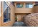 Inviting townhome front entry with brick privacy wall and wood plank siding at 9400 E Iliff Ave # 292, Denver, CO 80231