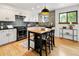 Modern kitchen with white cabinets, an island with seating, updated appliances, and an adjacent window at 9400 E Iliff Ave # 292, Denver, CO 80231