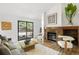 Bright living room featuring a brick fireplace, wood floors, modern decor, and sliding glass doors to the patio at 9400 E Iliff Ave # 292, Denver, CO 80231