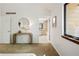 Bedroom view into en-suite bathroom featuring decorative lamp, round mirror, and large picture window at 9400 E Iliff Ave # 292, Denver, CO 80231