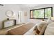 Bedroom featuring a decorative lamp, round mirror, and large picture window with natural light at 9400 E Iliff Ave # 292, Denver, CO 80231