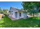 View of a well-kept backyard, showing the house's patio, lawn, and landscaping with a shade tree at 3915 Miller St, Wheat Ridge, CO 80033