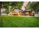Beautiful backyard with a spacious lawn, covered patio, and mature trees providing shade and privacy at 6740 S Windermere St, Littleton, CO 80120