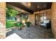 Inviting covered front porch with stone flooring, brick columns, potted plants, and a cozy armchair at 6740 S Windermere St, Littleton, CO 80120