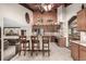 Open-concept kitchen with dark wood cabinets, stainless steel appliances, and a bar-style counter with seating at 6740 S Windermere St, Littleton, CO 80120