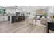 Open-concept layout seamlessly connecting the kitchen to the living room with wood floors and bright lighting at 11877 Keough Dr, Northglenn, CO 80233