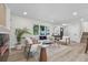 Bright living room featuring wood floors, fireplace, neutral furniture, and natural light from the large windows at 11877 Keough Dr, Northglenn, CO 80233