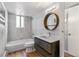 Updated bathroom with wood look floor, dark wood vanity, modern sink, and bathtub with tile surround at 3722 S Quebec St, Denver, CO 80237