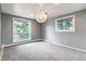 Bedroom features gray carpet, light gray walls, two windows with tree views, and a modern light fixture at 3722 S Quebec St, Denver, CO 80237