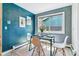 Cozy dining area with a glass table, four chairs, a window view, and modern wall art at 3722 S Quebec St, Denver, CO 80237