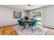 A bright dining room features a glass table, seating for four, an area rug and an adjacent patio at 3722 S Quebec St, Denver, CO 80237
