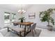 Bright dining room features modern lighting, a wood table, and a cozy bench with sliding door access to outdoor spaces at 3722 S Quebec St, Denver, CO 80237