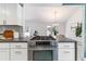 Kitchen island has gray counters, a stainless cooktop and oven, and a view of a plant-filled dining area at 3722 S Quebec St, Denver, CO 80237
