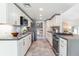 Galley kitchen features white cabinetry, gray countertops, stainless steel appliances, and subway tile backsplash at 3722 S Quebec St, Denver, CO 80237