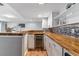 An attractive kitchenette with butcher block countertop, wine fridge, white cabinets, and modern backsplash at 3722 S Quebec St, Denver, CO 80237