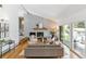 Bright living room with vaulted ceiling, modern fireplace, and sliding glass door to outside patio at 3722 S Quebec St, Denver, CO 80237