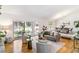 Bright living room with hardwood floors, a vaulted ceiling, and access to a dining area and backyard at 3722 S Quebec St, Denver, CO 80237