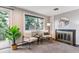 Cozy living room with a fireplace, comfortable chairs, and a large window with a tree view at 3722 S Quebec St, Denver, CO 80237