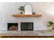 Modern fireplace with stylish brick, wooden mantle, and decorative accessories at 3722 S Quebec St, Denver, CO 80237