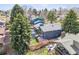 Aerial view of gray house with patio and backyard surrounded by lush green trees at 3722 S Quebec St, Denver, CO 80237