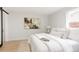 Bright bedroom featuring a sliding barn door and neutral decor and a large framed piece of art at 6285 S Oneida Way, Centennial, CO 80111