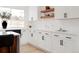 Bright kitchen featuring white cabinets, quartz countertops, floating shelves, and modern black hardware at 6285 S Oneida Way, Centennial, CO 80111