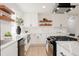 Modern kitchen with quartz countertops, stainless steel appliances, and wooden shelving, creating a sleek design at 6285 S Oneida Way, Centennial, CO 80111