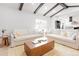 Bright living room with exposed ceiling beams offers an open view into the updated kitchen at 6285 S Oneida Way, Centennial, CO 80111