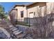 Backyard stone steps and wrought iron fence with lush shrubbery, enhancing the home's charm and outdoor appeal at 8310 Raphael Ln, Littleton, CO 80125