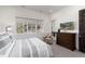 Bedroom features a comfortable bed, large window with views, and a wooden dresser adding to the room's cozy and inviting ambiance at 8310 Raphael Ln, Littleton, CO 80125