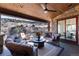 Relaxing covered patio with comfortable seating, stone fireplace, and scenic views of the surrounding mountains at 8310 Raphael Ln, Littleton, CO 80125