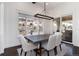 Bright dining area with large windows showcasing hill views, modern chandelier, and access to covered porch at 8310 Raphael Ln, Littleton, CO 80125