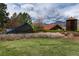 Community entrance with artistic signage, mature trees, and charming architecture creating a welcoming atmosphere at 8310 Raphael Ln, Littleton, CO 80125