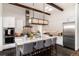 Modern kitchen featuring white cabinetry, large island with seating, and stainless steel appliances, with pendant lights at 8310 Raphael Ln, Littleton, CO 80125