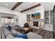 Cozy living room with a stone fireplace, wood beams, and comfortable sectional sofa at 8310 Raphael Ln, Littleton, CO 80125