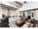 Bright, open living space with high ceilings, wood beams, modern lighting, and seamless flow to kitchen at 8310 Raphael Ln, Littleton, CO 80125