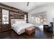 Serene main bedroom featuring wood accent wall, plush bedding, and ample natural light at 8310 Raphael Ln, Littleton, CO 80125