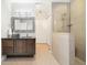 Bathroom featuring a walk in shower with tile surround, a dark wood vanity and modern lighting fixture at 1882 W 67Th Ave, Denver, CO 80221