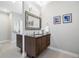 Bathroom featuring a dark wood vanity with sink and mirror and art hanging on the walls at 1882 W 67Th Ave, Denver, CO 80221