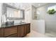 Bathroom featuring a walk in shower with tile surround, a dark wood vanity and modern lighting at 1882 W 67Th Ave, Denver, CO 80221